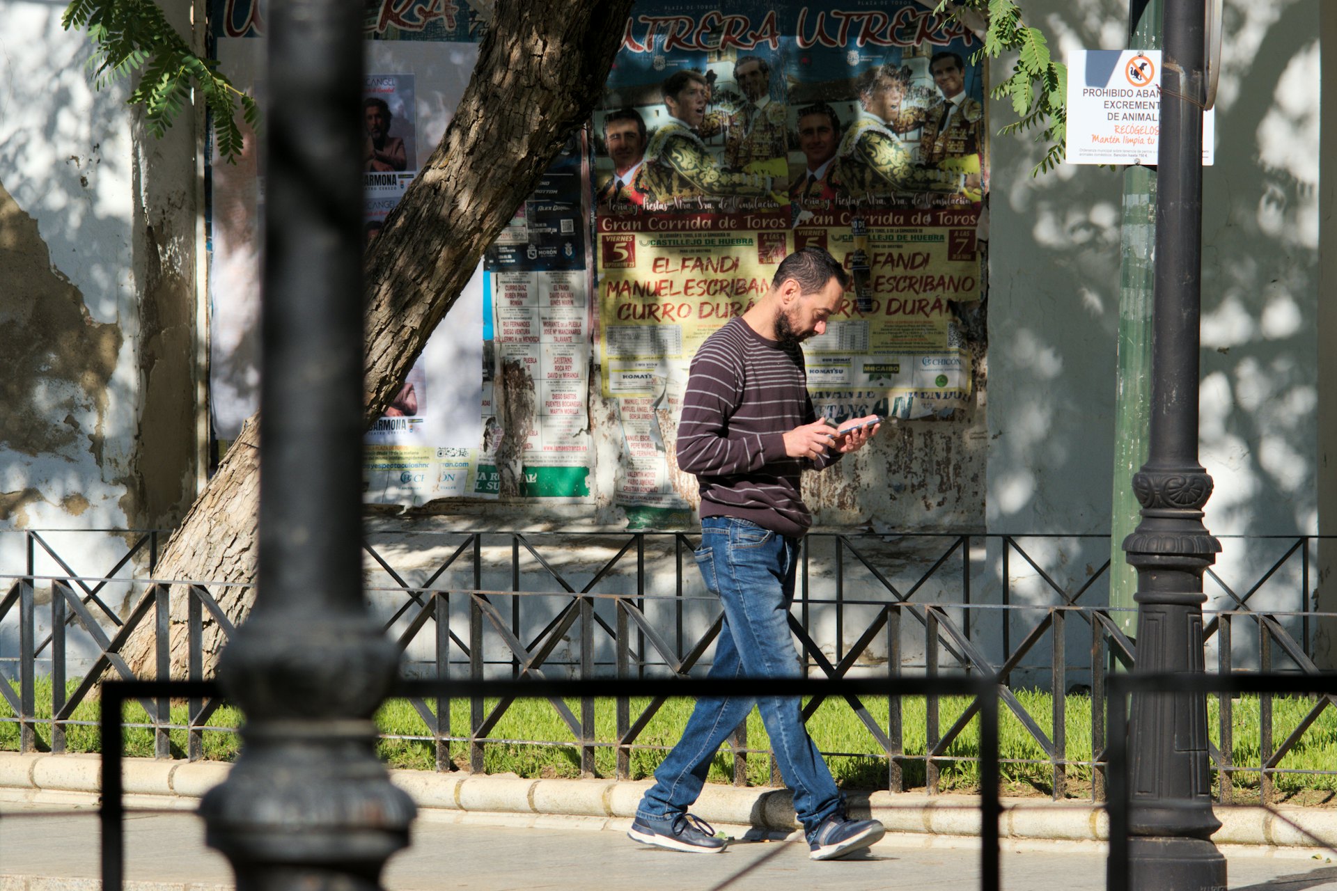 Persona caminando por la calle mientras busca en el móvil